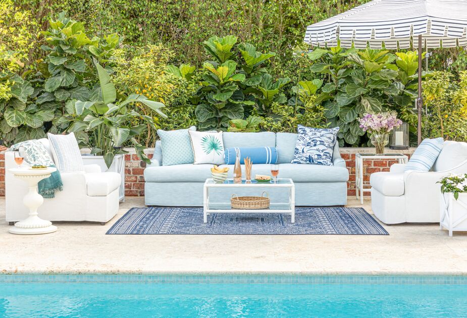 Blue themed patio furniture by a pool. summer outdoor decor trends